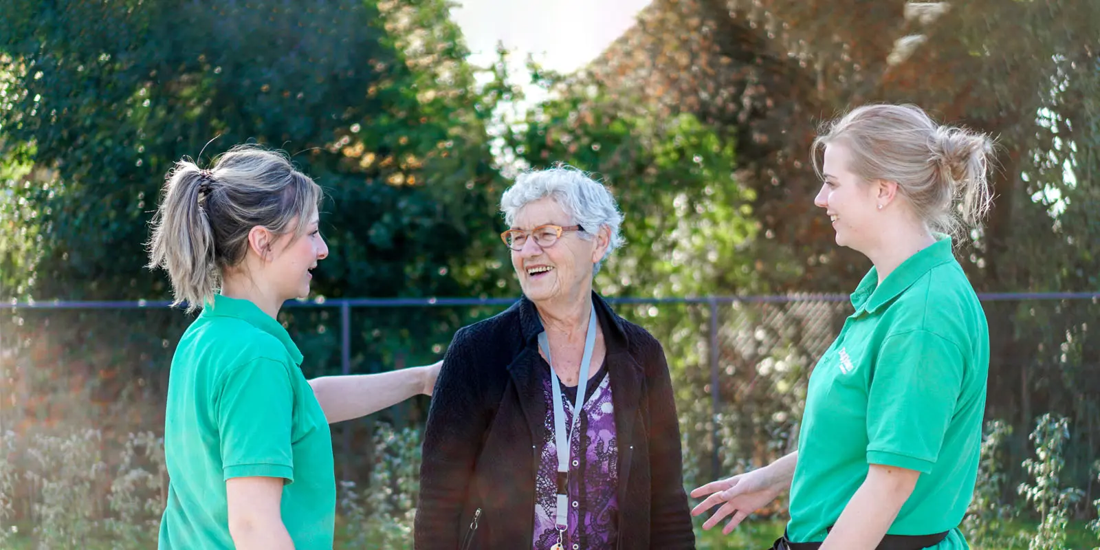 Twee medewerkers en een bewoner maken contact