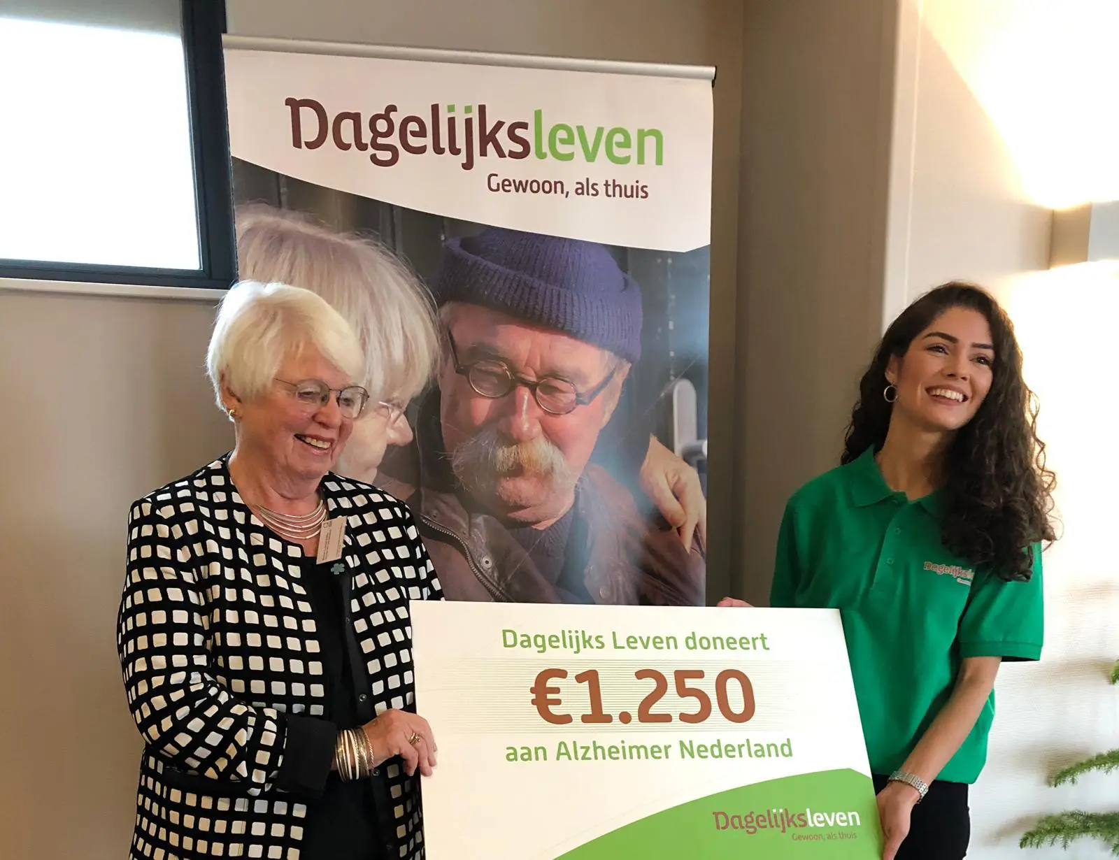 Een medewerker van Het Vandermolenhuis overhandigt een cheque aan alzheimer nederland