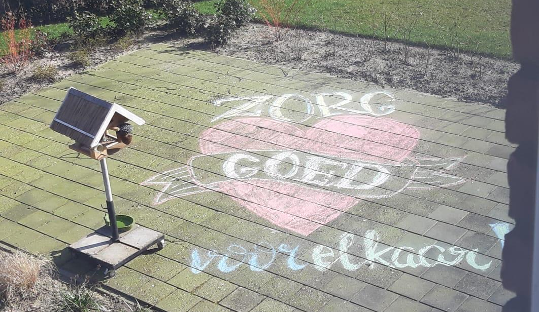 Een stoepkrijt tekening bij Het Vijverberghuis hier staat zorg goed voor elkaar