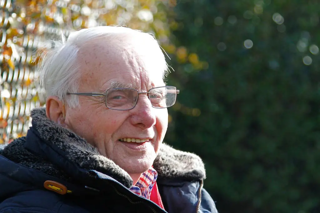 Meneer Willemsen zit buiten te genieten van de zon in Het Wilderinkhuis in Hengelo