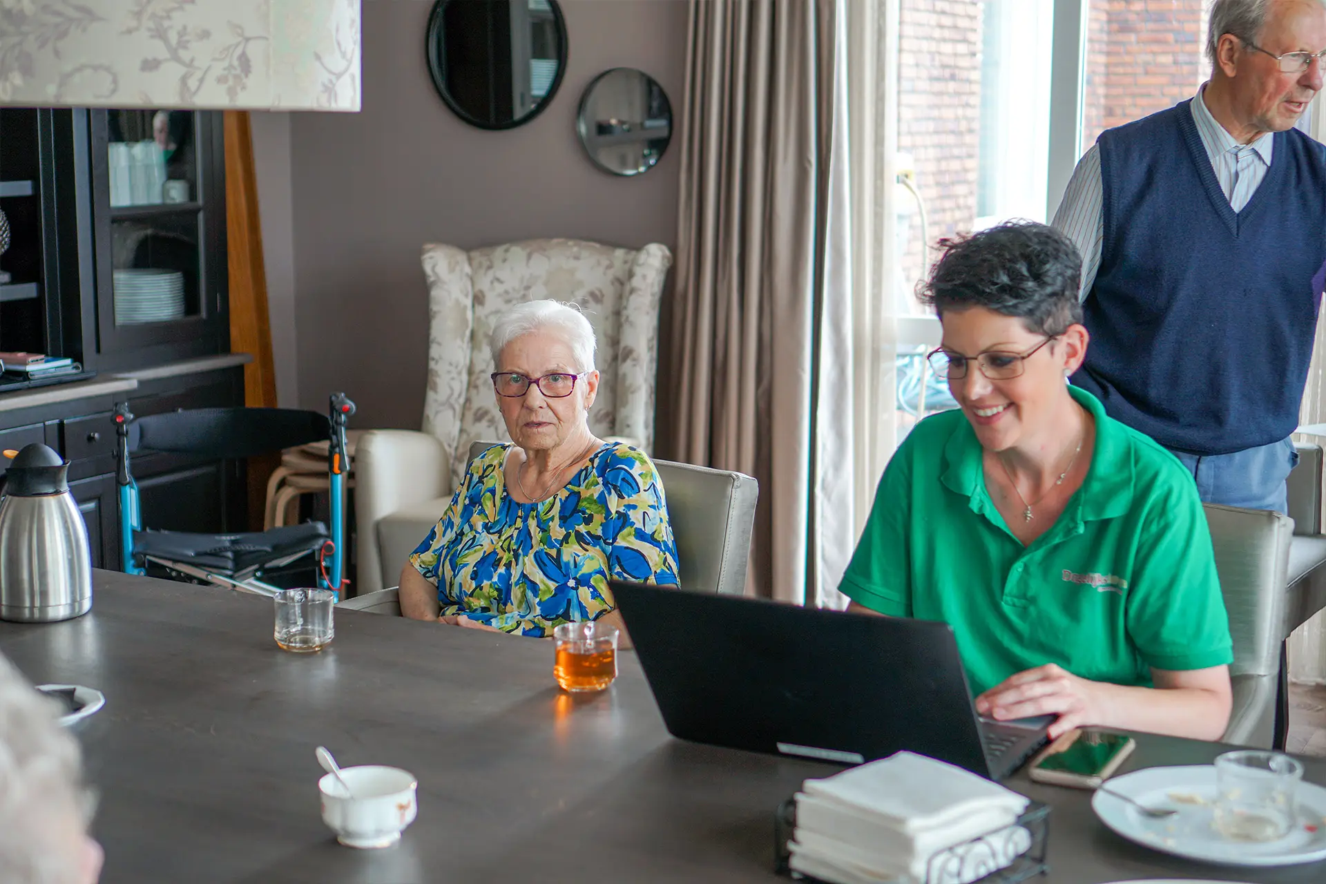 Bewoner en medewerker zitten samen aan de tafel in Het Beekdalhuis in Wierden