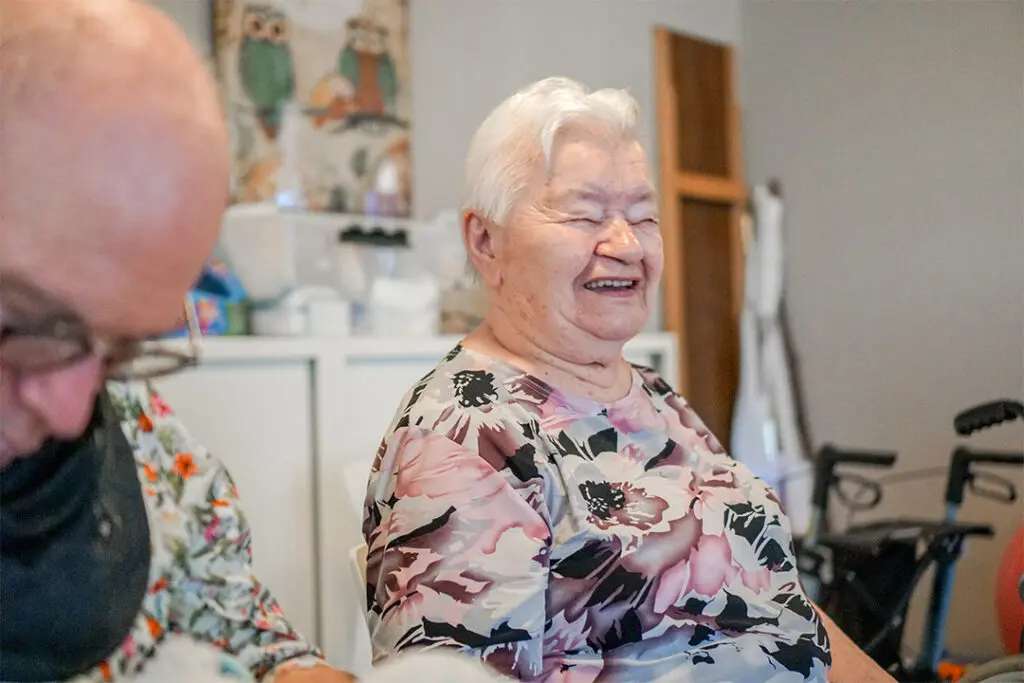 Een mevrouw die woont bij dagelijks leven lacht tevreden
