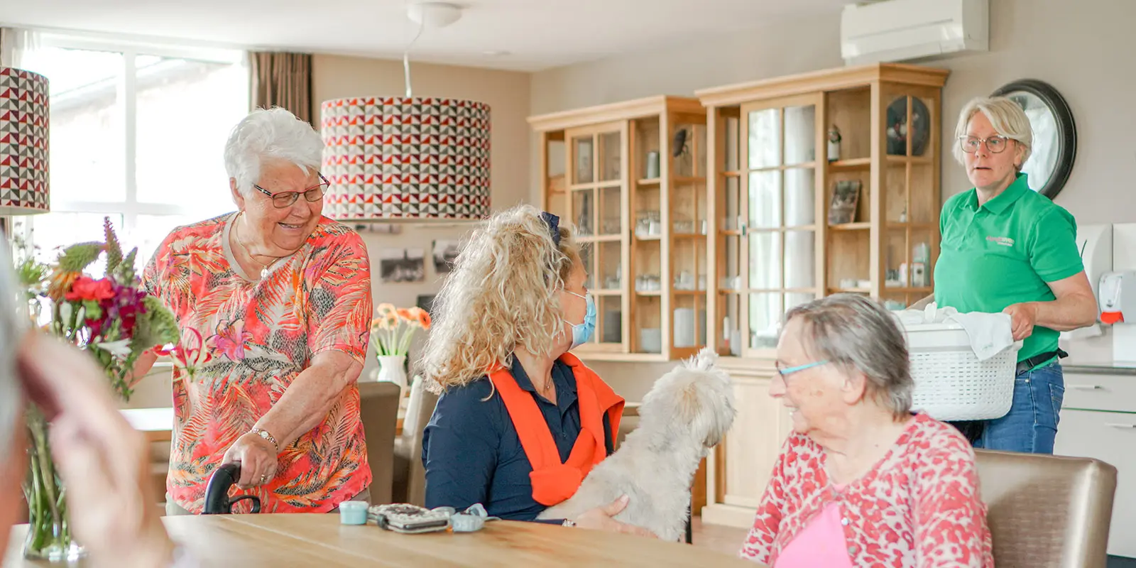 Sfeerimpressie van bewoners, een verwant en medewerker in een woonkamer van Dagelijks Leven