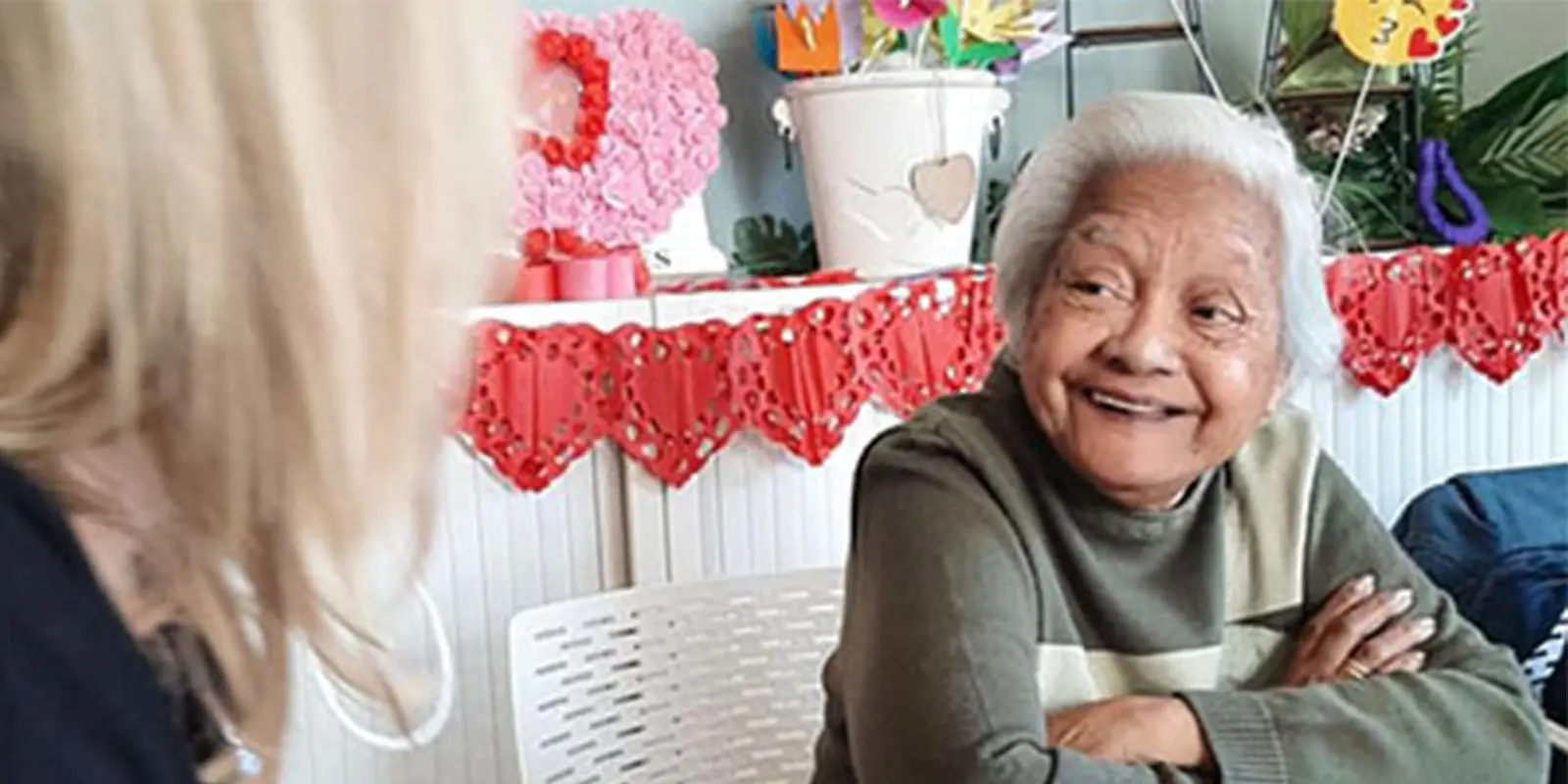 Een bewoner lacht naar de locatiemanager tijdens de bewonersraad, die werd gehouden aan de hand van een potje ganzenbord.