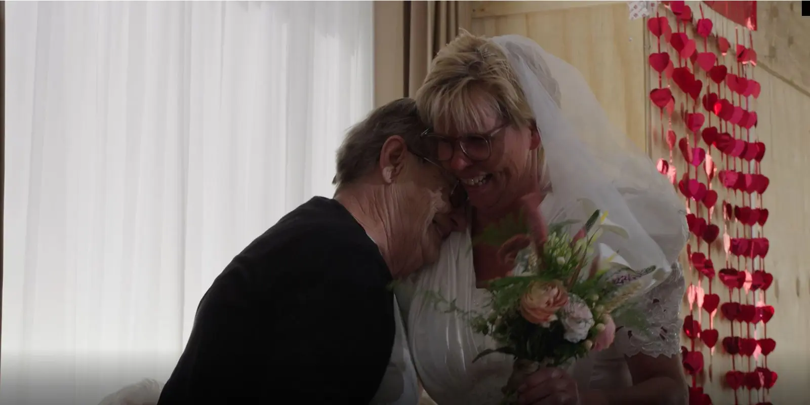 Bij Dagelijks Leven doen we ons best om de hartenwensen van onze bewoners met dementie te vervullen. Zo ook die van deze bewoonster, die haar dochter graag in een trouwjurk zou zien. Die wens kwam uit: op de foto zien we de bewoonster in tranen, knuffelen met haar dochter die.... een trouwjurk aanheeft,