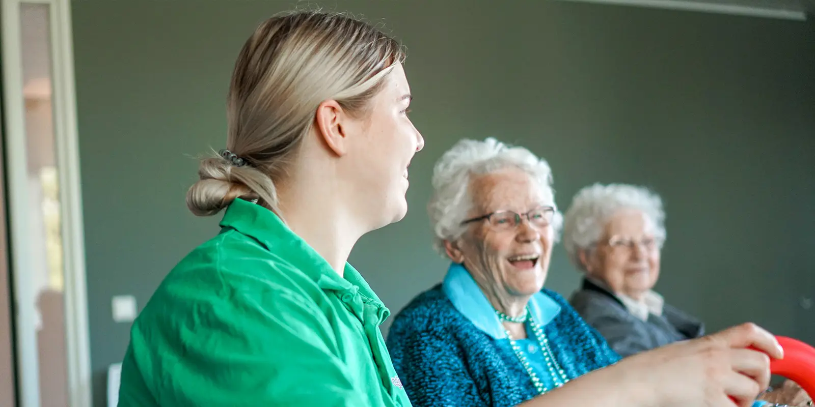 ZZP'er zit aan tafel met twee bewoners tijdens een activiteit