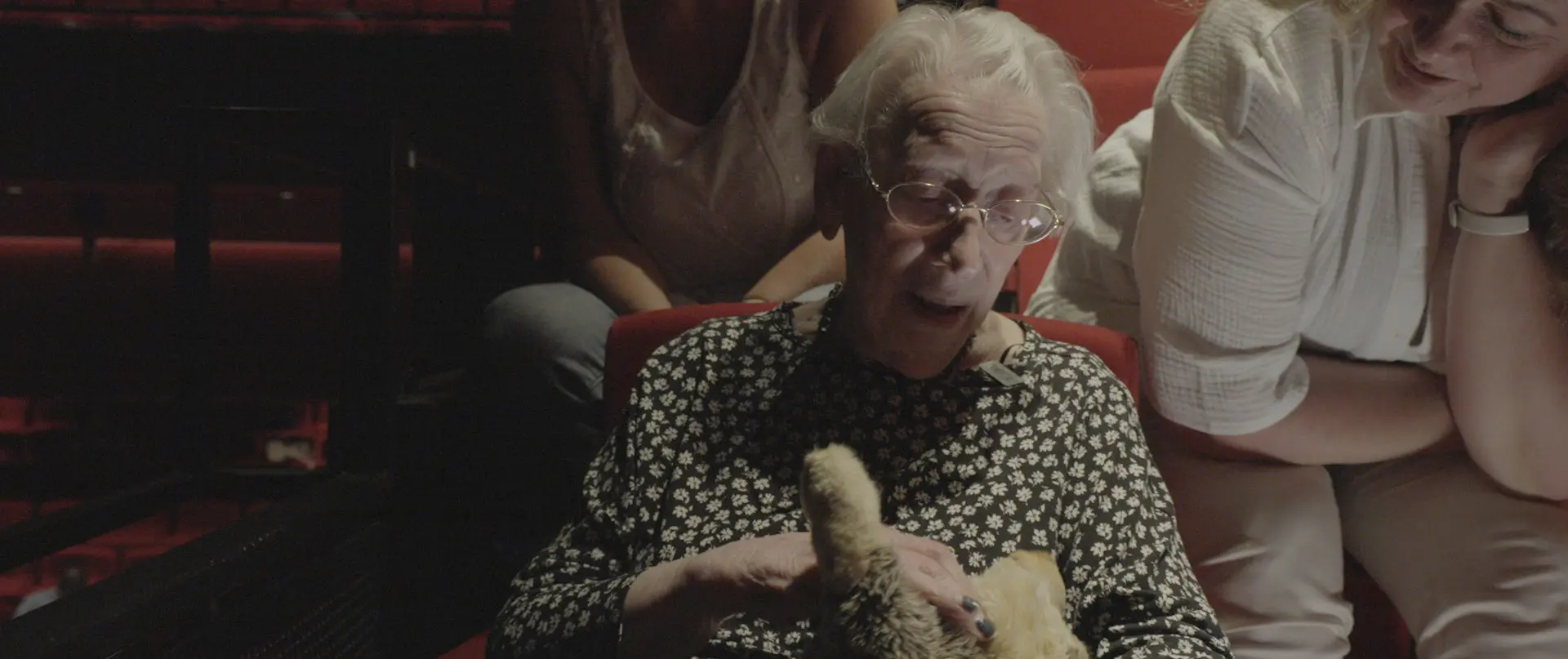 Bewoonster met dementie in het publiek bij een balletvoorstelling.