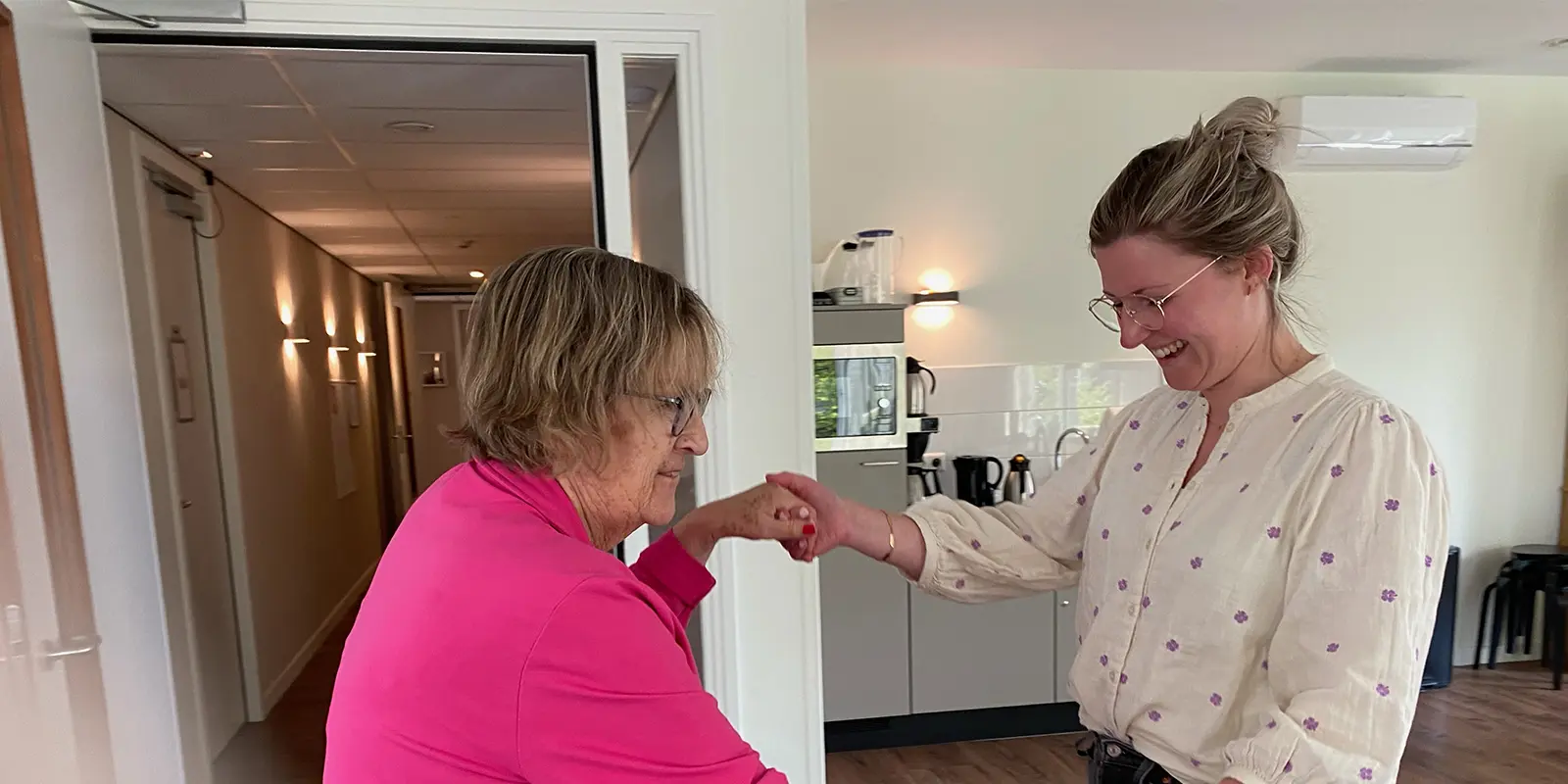 Loes is psycholoog in de ouderenzorg voor mensen met dementie en voelt zich soms net een dansende kameleon. Op de foto danst ze met een bewoner.