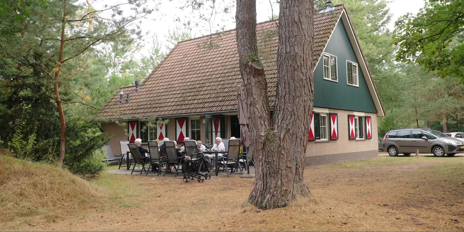 Als je in een woonzorglocatie woont vanwege dementie, is het niet vanzelfsprekend om je koffer te pakken en op reis te gaan. Deze bewoners van Het Staatsliedenhuis in Apeldoorn gingen toch. Op de foto zitten ze voor de vakantiewoning op het terras.