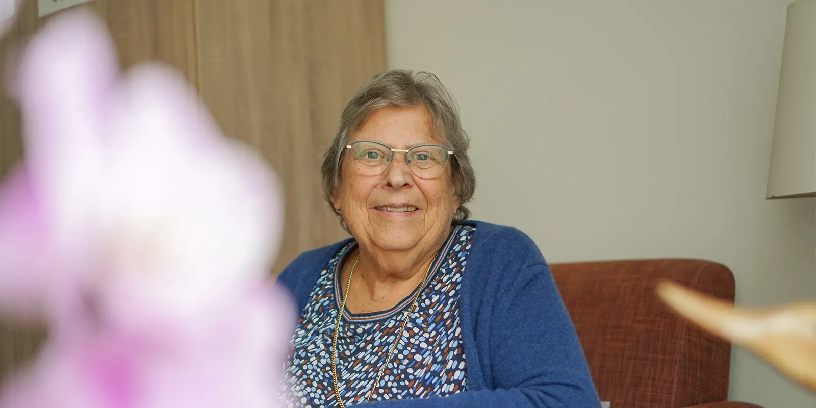 Portretfoto van de bewoner in haar studio in de woonzorglocatie voor mensen met dementie in Geldermalsen. Hoewel ze er nooit zit.