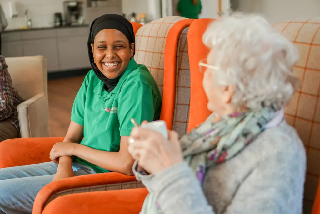 Een stagiaire kletst met een bewoonster met alzheimer in de kleinschalige zorglocatie voor mensen met dementie van Dagelijks Leven