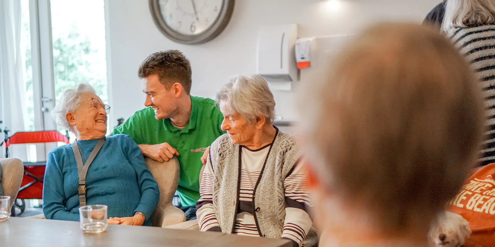 Een bewoonster met dementie en de activiteitenbegeleider lachen om een grapje.