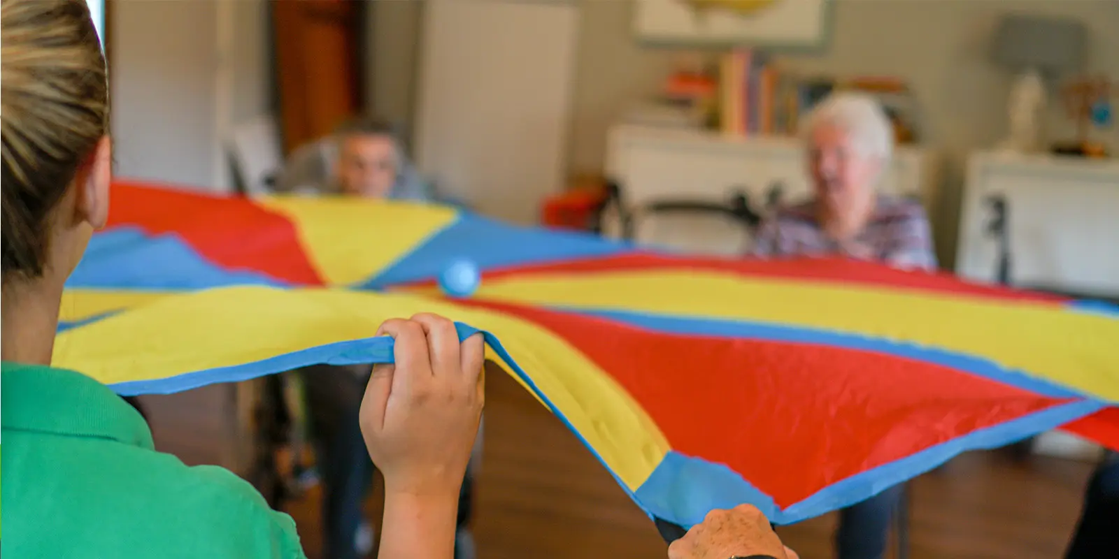 Foto van een beweegactiviteit op een kleinschalige woonzorglocatie voor mensen met dementie van Dagelijks Leven. Ter illustratie bij blog van een verpleegkundig specialist die vertelt over de eerste SI-behandeling (sensorische informatieverwerking) voor mensen met dementie bij Dagelijks Leven.