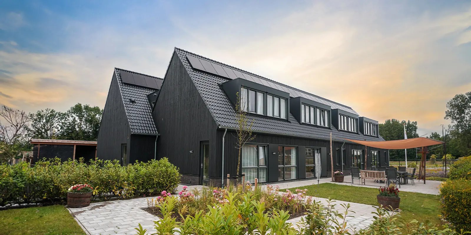 Foto van Het Buitenvestehuis van Dagelijks Leven in Steenbergen. Hier wonen mensen met dementie, zoals Alzheimer in een kleinschalige setting bij elkaar. De woonzorglocatie heeft een grote tuin.