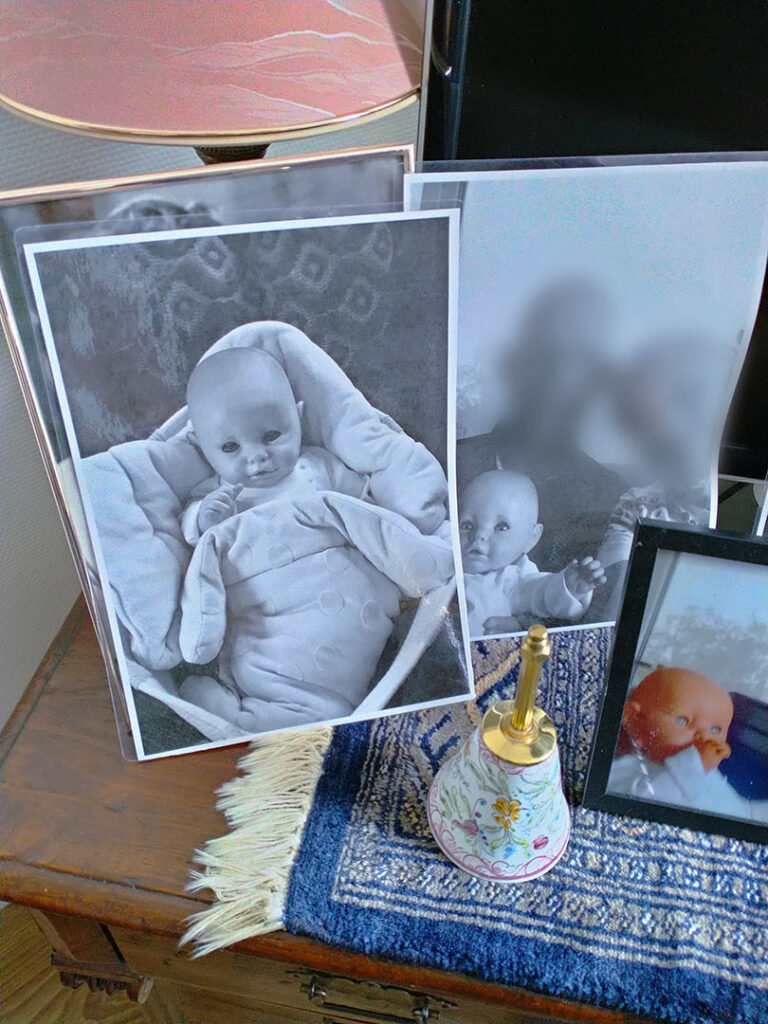 familiefoto's met een babypop op het kastje in de kamer van een mevrouw met dementie bij Dagelijks Leven