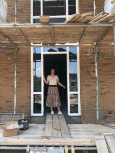 Locatiemanager van Het Blaauwhofhuis in Joure in de deuropening van de kleinschalige woonzorglocatie voor mensen met dementie