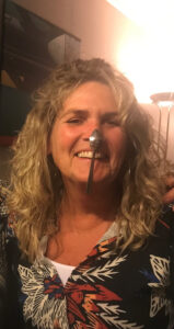 Activiteitenbegeleider van de woonzorglocatie voor mensen met dementie lachend op de foto met een lepel op haar neus.